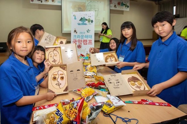 ▲ 한국메세나협회와 크라운해태제과가 함께한 '2019 크라운해태 국악캠프'가 열린 12일 경기 양주시 크라운해태 연수원에서 참가자가 과자로 얼굴모양을 만들고 있다.ⓒ한국메세나협회