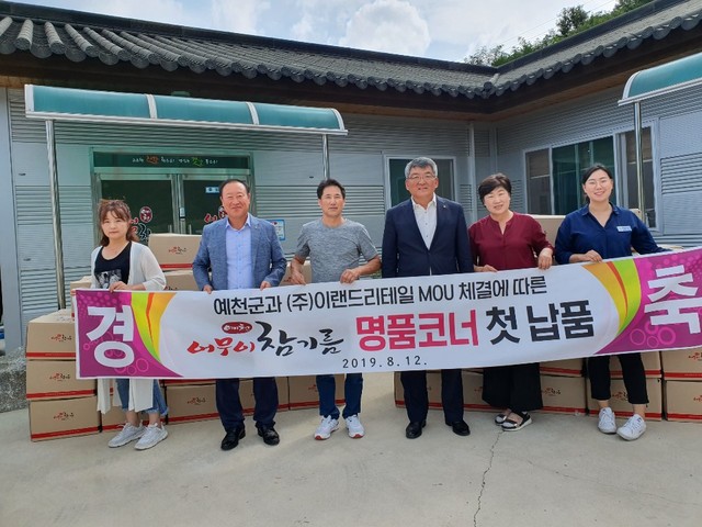 ▲ 예천군의 대표 특산물인 어무이 참기름이 12일 우리나라 최대 유통업체인 ㈜이랜드리테일에 첫 납품을 하면서 김학동 군수(오른쪽 세번째) 등이 축하해 주고 있다.ⓒ예천군