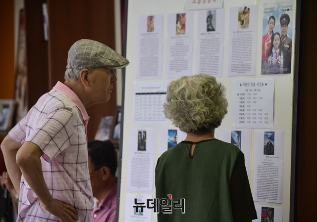 ▲ 영화 '사랑의선물' 상영 시간표를 촬영하는 시민