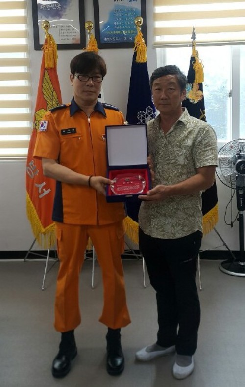 ▲ 16일 원재현 단양소방서장(왼쪽)이 용감한 군민 남영주씨에게 감사패를 전달하고 기념촬영을 하고 있다.ⓒ단양소방서