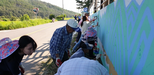 ▲ 마을주민들과 행사 참가자들이 벽화를 그리고 있는 모습.ⓒ경북농협