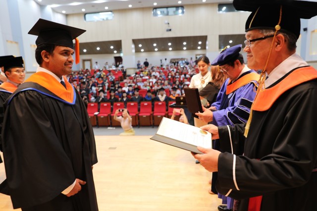 ▲ 22일 한국교통대 충주캠퍼스 대학본부 2층 국제회의장에서 열린 ‘2018학년도 후기 학위수여식’에서 인도 유학생 '리뷰라이 비슈느'가 박준훈 총장(오른쪽)으로부터 박사학위를 받고 있다.ⓒ한국교통대