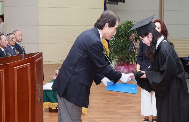 ▲ 청석학원 표갑수 이사장이 23일 보건의료과학대학 청암홀에서 열린 2018학년도 후기 학위수여식에서 항공운항학과 이혜원씨에게 학사학위 증서를 전달하고 있다.ⓒ청주대