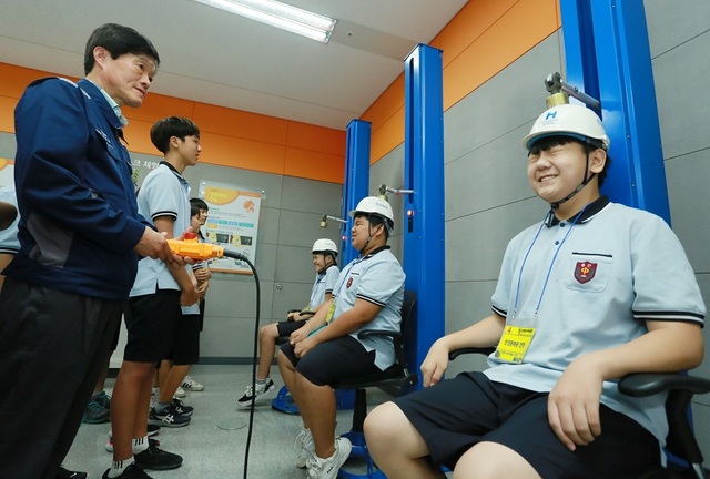 ▲ 충남 당진 송산중학교 학생들이 지난 23일 현대제철 당진제철소 안전문화관에서 안전모의 중요성과 역할을 알기 위해 충격감소를 체험하고 있다. ⓒ현대제철 당진제철소