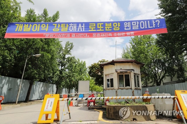 ▲ 서울 강동구 둔촌주공 아파트 재건축 현장에 분양가상한제를 반대하는 조합원들의 현수막이 걸려있다. ⓒ연합뉴스