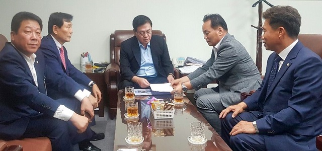 ▲ 26일 자유한국당 정우택 의원(청주 상당)이 김병국 청주시의원 등으로부터 충북도당위원장직을 맡아줄 것을 요구하는 건의서를 받아들고 있다.ⓒ자유한국당 충북도당