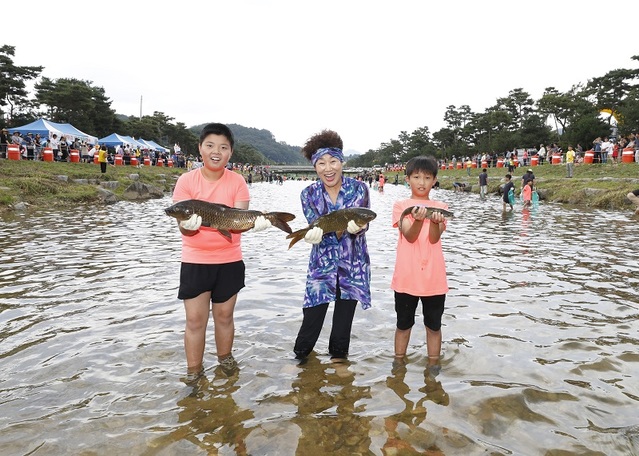 ▲ 괴산군 홍보대사인 배우 장정희씨가 어린이들과 함께 동진천에서 고추달린 물고기 잡기에 흠뻑 빠졌다.ⓒ괴산군