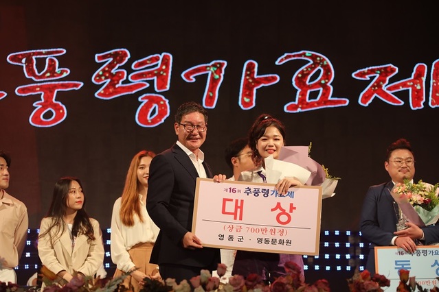 ▲ 박세복 영동군수가 지난 31일 열린 끼와 젊은의 향연, 대한민국 대표가요제로 자리매김한 추풍령가요제에서 대상을 받은 이소윤 씨(21·여·대전)에게 상금 700만원을 전달하고 있다.ⓒ영동군