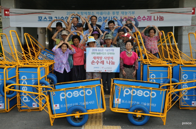 ▲ 사랑의 손수레 전달 후 기념사진 모습(뒷줄 왼쪽 3번째 김무장 연일읍장, 왼쪽 4번째 박동명 포스코기술연구원 그룹장).ⓒ포스코