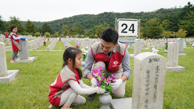 ▲ 롯데건설 '샤롯데봉사단'이 국립서울현충원에서 묘역 단장 봉사활동을 진행하고 있다. ⓒ롯데건설