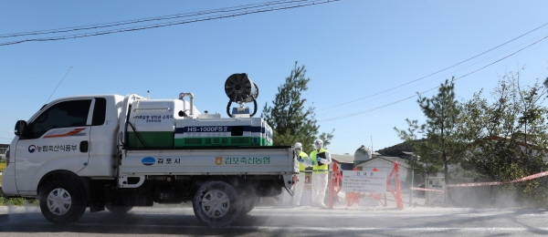 ▲ 지난 23일 오전 아프리카 돼지열병(ASF) 의심 신고가 접수된 경기도 김포시의 한 돼지농장 입구 도로에서 방역관계자들이 방역을 하고 있다. ⓒ뉴시스