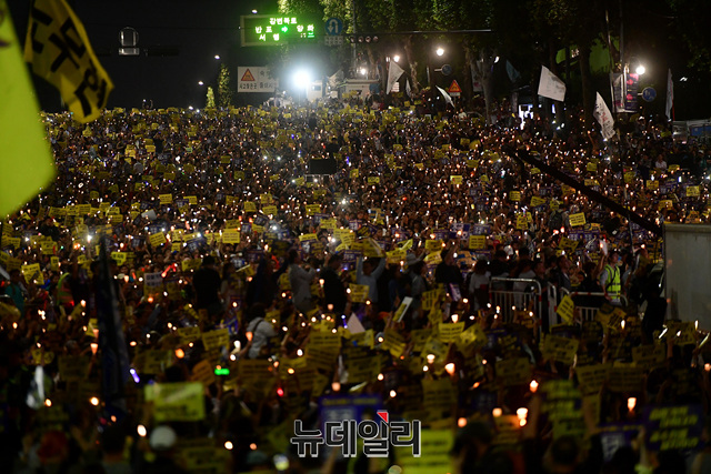 ▲ 조국을 지지하는 시민들이 지난 28일 오후 서울 서초구 서초대로에서 열린 집회에서 촛불을 들고 있다. 경찰은 대검찰청 앞에서 열린 조국 사퇴 집회 참가자들과 충돌을 막기 위해 펜스를 설치했다. 이날 서초구의 서리풀축제로 반포대교부터 서초대로가 차량통행이 차단됐다. ⓒ정상윤 기자