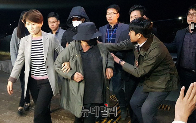 ▲ 지난 4월 8일 오후 11시경 충북 제천경찰서로 압송되고 있는 마이크로닷 부모. 검은색 마스크를 쓰고 앞서 가고 있는 여성이 마이크로닷의 모친, 흰색 마스크를 쓰고 뒤따라가는 남성이 마이크로닷의 부친이다. ⓒ목성균 기자