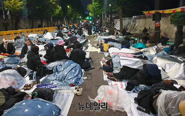 ▲ 9일 밤 10시쯤 청와대 분수대광장 앞에서 300여 명의 시민들이 '철야 노숙시위'를 위해 담요를 덮고 취침 준비를 하고 있다. 이날 밤 체감온도는 3~4도였다. ⓒ박찬제 기자