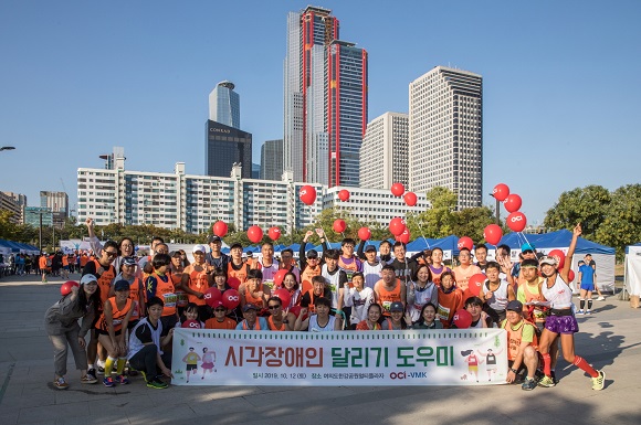 ▲ 지난 10월 12일, 여의도한강공원에서 열린 시각장애인 마라톤 대회에서 참가들과 봉사자들이 단체사진을 찍고 있다.ⓒOCI