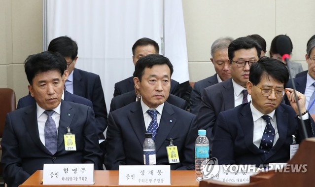 ▲ 21일 오후 국회에서 열린 정무위원회의 금융위원회, 금융감독원 등의 종합 국정감사에 증인으로 출석한 함영주 하나금융그룹 부회장(왼쪽부터), 정채봉 우리은행 부행장, 장경훈 하나카드 대표이사가 참고인으로 출석한 해외금리연계 파생결합펀드(DLF) 피해자가 뒤쪽 가림막에서 증언을 하자 무거운 표정을 하고 있다. ⓒ연합뉴스