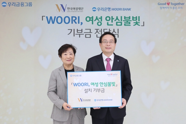 ▲ 손태승(오른쪽) 우리금융 회장이 이혜경 한국여성재단 이사장에게 안심불빛과 비상벨설치에 사용될 기부금을 전달하고 기념촬영을 하고 있다.ⓒ우리금융