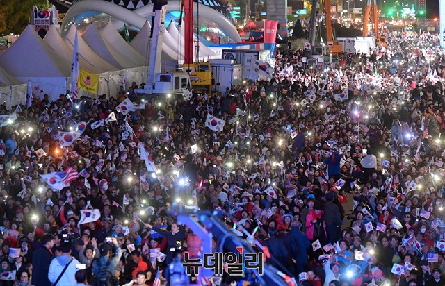 ▲ 25일 밤 11시 서울 광화문 세종문화회관 앞에서 문재인하야범국민투쟁본부(투쟁본부)가 주최한 '문재인 하야 촉구 3차 범국민대회'에 참석한 일부 참가자들은 밤새 자리를 지켰다. 갑자기 기온이 떨어진 날씨에도 이날 집회는 사뭇 축제처럼 즐거운 분위기 속에 진행됐다. ⓒ정상윤 기자