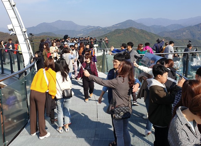 ▲ 단양 만천하스카이워크 정상 만학천봉전망대에 올라 소백산을 배경으로 기념사진을 촬영하고 있는 관광객들.ⓒ단양군