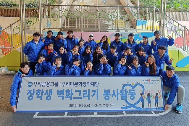 ▲ 우리금융 우리다문화장학재단 대학생 40여명이 서울 신상도초등학교에서 벽화그리기 봉사활동 후 사진촬영을 하고 있다.