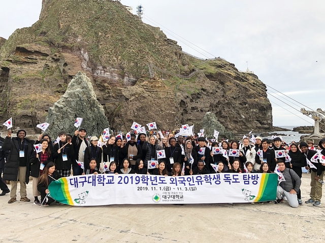 ▲ 지난 2일 대구대 외국인 유학생들이 독도를 찾아 태극기 퍼포먼스를 펼친 후 단체 기념사진을 찍고 있다.ⓒ대구대