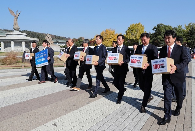 ▲ 양승조 충남도지사와 충남혁신도시범도민유치추진위원들이 7일 충남도민 100만명 서명부를 들고 청와대로 향하고 있다. ⓒ충남도