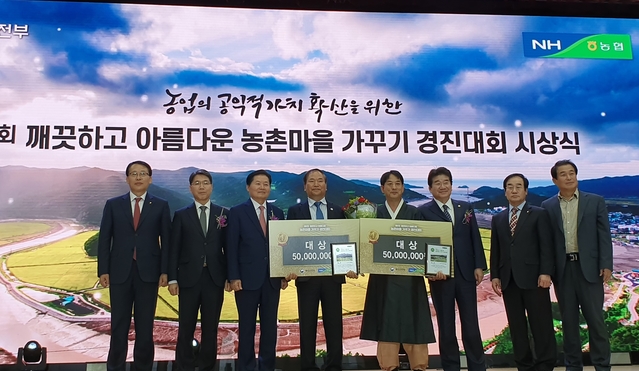 ▲ 농협중앙회 김병원 회장(왼쪽 세번째)과 강석호 국회의원(오른쪽 세번째)이 마을 대표(중앙)들과 대상 수상 기념사진 장면.ⓒ경북농협