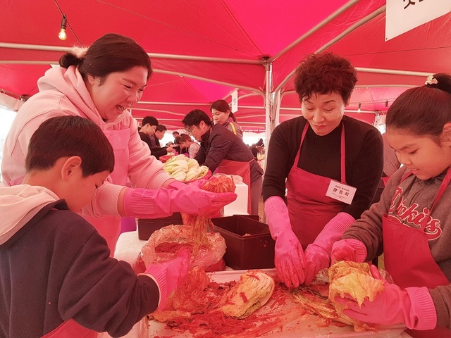 ▲ 충북 괴산군 홍보대사 배우 장정희씨가 지난 9일 괴산읍 동진천 축제장에서 열린 ‘2019 괴산김장축제장’에서 ‘우리가족 김장담그기’에 참여한 가족팀과 함께 김장김치를 만들고 있다. 장 씨는 이날 축제장을 찾은 소비자들을 대상으로 괴산의 대표 농·특산물인 절임배추 홍보 활동을 펼쳤다. 괴산군 괴산읍이 고향인 장씨는 1978년 KBS 10기 공채 탤런트로 데뷔해 드라마 ‘토지’, 시트콤 ‘순풍산부인’과 등 다수의 작품에서 개성 있는 연기력으로 인기를 끌었다.ⓒ괴산군