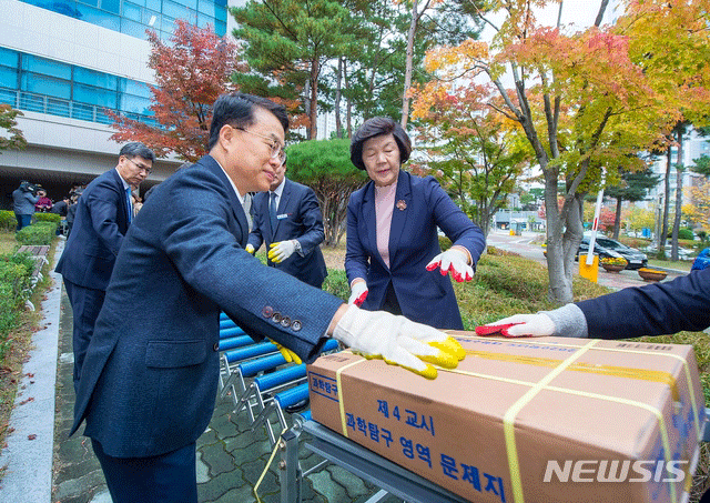 ▲ 2020학년도 대입수학능력시험일을 사흘 앞둔 11일 오후 울산시교육청 고사관리실에서 노옥희 시교육감과 이용균 부교육감이 수능 문제지와 답안지 하차를 돕고 있다. ⓒ뉴시스