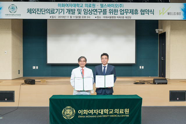 ▲ 지난  11일 오후 2시 이대서울병원 지하 2층 대강당에서 열린 이화여자대학교 의료원과 웰스바이오의 체외 진단 의료기기 개발·임상연구를 위한 업무제휴 협약식에서 문병인 의료원장(왼쪽)과 이근형 공동대표가 협약서 사인 후 기념 촬영을 하고 있다. ⓒ이화여자대학교 의료원