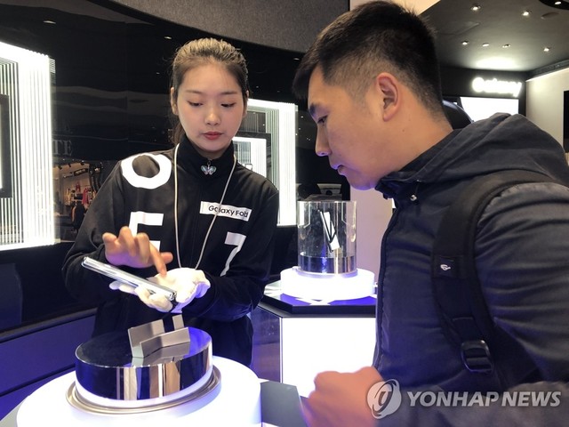 ▲ 내년 스마트폰 산업은 5G(5세대 통신기술)스마트폰 시장 확대와 폴더블 스마트폰 출하 증가로 수요 확대가 예상된다. 사진은 이달 8일(현지시간) 중국 상하이 번화가 난징둥루에 있는 삼성전자 플래그십 매장에서 고객이 전시된 갤럭시 폴드 실물을 살펴보는 모습.ⓒ연합뉴스