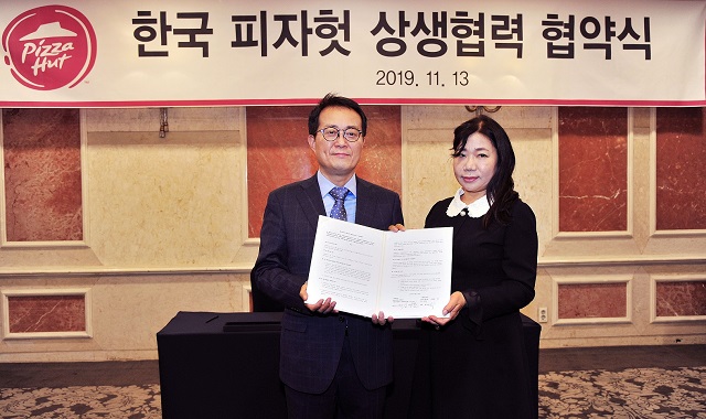 ▲ 김명환 한국피자헛 대표와 윤혜순 피자헛가맹점주협의회장(피가협회장)이 상생협약 체결 후 협약서를 펼쳐보이고 있다. 
 ⓒ한국피자헛