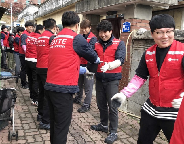 ▲ 15일 롯데주류 충주공장 직원들로 구성된 샤롯데봉사단이 충주시 관내 저소득층에 연탄을 전달하고 있다. 이날 롯데주류는 42가구에 연탄 1만2700장을 직접 배달해 줬다.ⓒ충주시