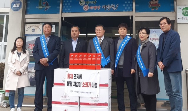 ▲ 김두진 사회정상화운동분부 이사장(가운데)과 김부환 (주)미창 대표이사(왼쪽 두번째)가 어상천면에 소화기 120개를 전달하고 면사무소 관계자들과 기념촬영을 하고 있다.ⓒ단양군