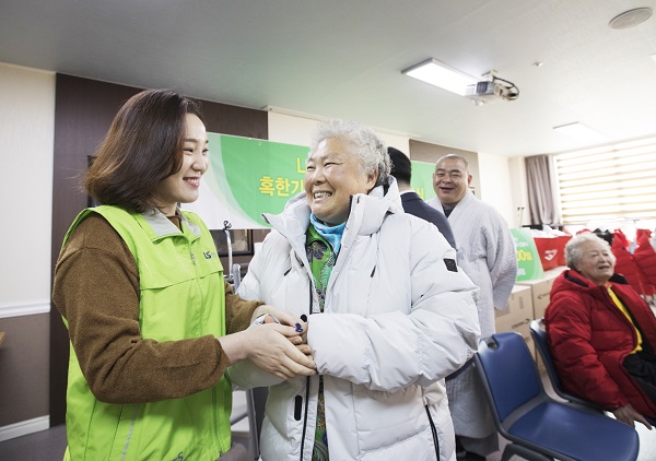 ▲ LS산전 봉사단원이 독거노인에 방한복을 입히고 있다. ⓒLS산전