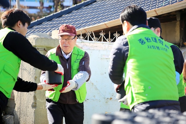 ▲ 김두년 총장과 교직원, 학생들이 지난 22일 괴산지역 어려운 이웃에 연탄을 배달하고 있다.ⓒ중원대학교