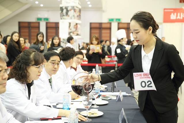 ▲ 대회에 참여한 학생이 심사위원들에게 와인을 추천하고 있다.ⓒ대구한의대