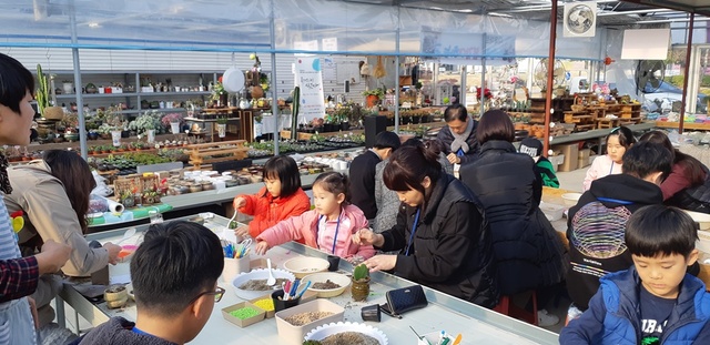 ▲ ‘충주애(愛)퐁당’9차 프로그램에 참여한 가족단위 여행객들이 다육이 심기 체험을 하고 있다.ⓒ충주시