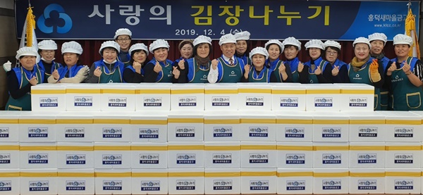 ▲ 김정복 청주흥덕새마을금고 이사장과 푸르미 봉사단원들이 김치 박스 앞에서 파이팅을 외치고 있다.ⓒ청주흥덕새마을금고