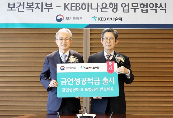 ▲ 정춘식 KEB하나은행 부행장(왼쪽)과 노홍인 보건복지부 보건의료정책실장이 지난 18일 을지로 본점에서 '국가금연 지원서비스'와 연계한 '금연성공 적금' 출시 업무협약을 맺고 기념촬영을 하고 있다. ⓒKEB하나은행