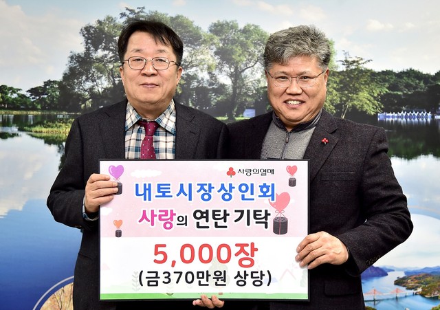 ▲ 지난 26일 김정문 제천 내토재래시장 상인회장(오른쪽)이 이상천 제천시장에게 연탄을 전달하고 있다.ⓒ제천시