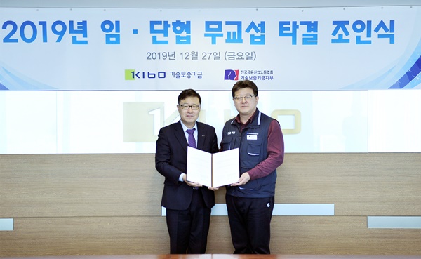 ▲ 정윤모 기보 이사장이 지난 27일 서울 여의도 63스퀘어에서 열린 '2019년 임금·단체협상 무교섭 타결 조인식'에서 채수은 노조위원장과 기념촬영을 하고 있다. ⓒ기술보증기금