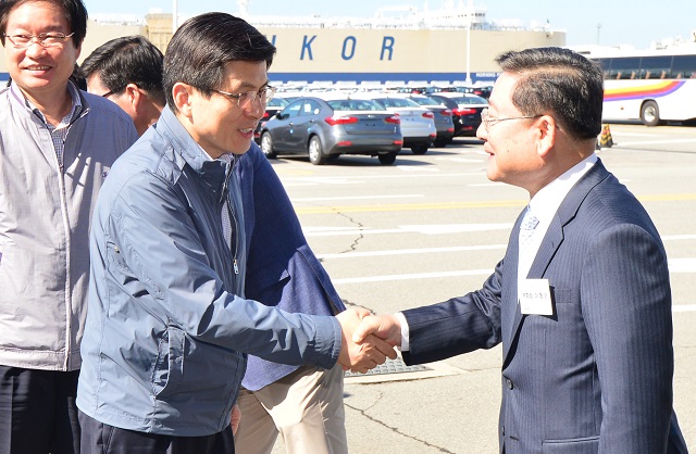 ▲ 황교안 국무총리가 2015년 9월 29일 경기 평택항 기아자동차 수출차량 전용부두를 찾아 이형근 기아차 부회장과 악수하고 있다. ⓒ뉴시스