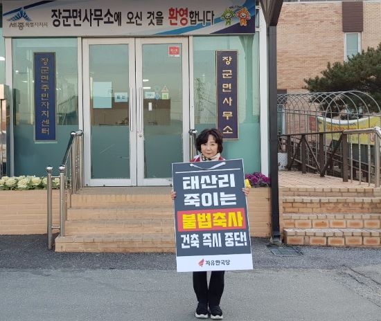 ▲ 송아영 자유한국당 세종시당위원장이 21일 세종시 장군면 태산리의 대규모 불법축사 건축을 즉시 중단해 줄 것을 요구하며 1인 시위를 진행하고 있다.ⓒ자유한국당 세종시당