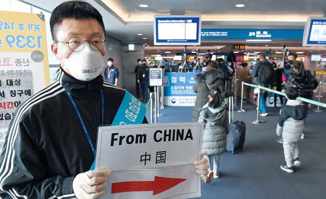 인천공항 검역관계자가 중국에서 입국한 사람들은 이쪽으로 오라는 안내문을 들고 있다. 모든 중국인이 이 안내를 따를지는 미지수다. ⓒ뉴시스. 무단전재 및 재배포 금지.