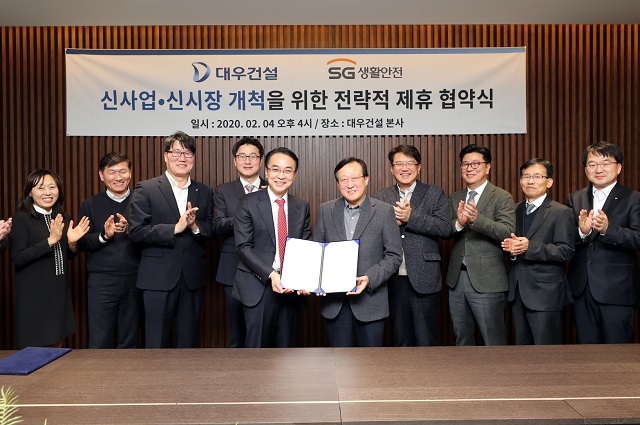 ▲ 김창환 대우건설 신사업본부장 전무(사진 왼쪽 6번째)와 이상룡 SG생활안전 대표(왼쪽 5번째) 등이 전략적 사업제휴를 위한 양해각서를 체결하고 기념사진을 촬영하고 있다.ⓒ대우건설