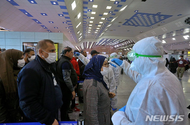▲ 이라크 나자프 공항 방역 관계자들이 이란에서 귀국하는 자국민을 대상으로 발열검사를 하고 있다. ⓒ뉴시스 AP. 무단전재 및 재배포 금지.