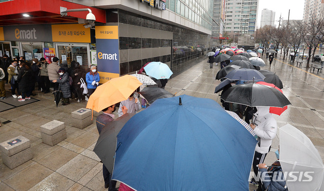 ▲ 25일 오전 대구 북구 침산동 이마트 앞에서 시민들이 우산을 쓴 채 마스크를 구입하기 위해 줄 서 있다.ⓒ뉴시스