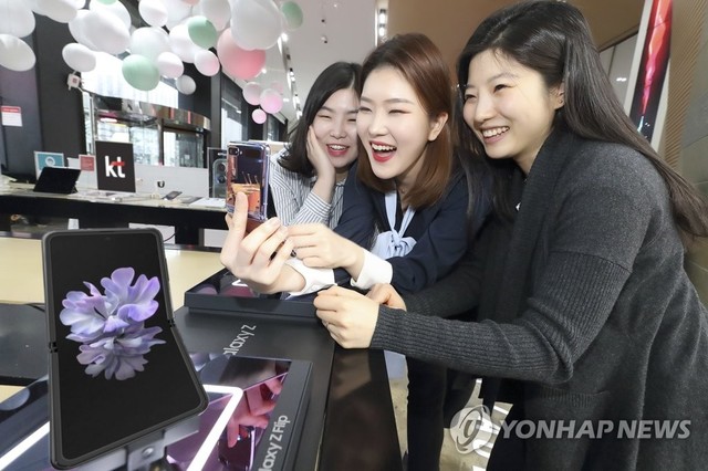 ▲ 갤럭시 Z 플립은 두께 0.03㎜의 극도로 얇은 유리를 사용해 화면이 울지 않고 고르게 펴진 평탄도를 개선했다. 사진은 서울 광화문 KT스퀘어에서 고객들이 갤럭시 Z Flip을 사용하는 모습.ⓒ연합뉴스