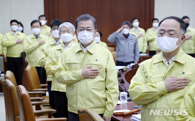 ▲ 문재인 대통령이 지난 3일 서울에서 열린 국무회의에 참석해 국기에 대한 경례를 하고 있다. 문 대통령고 정부 관료들은 모두 KF94 마스크를 착용하고 있다. ⓒ뉴시스